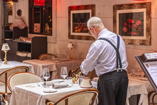 VENICE, ITALY 2 JULY 2020: Waiter prepares the table