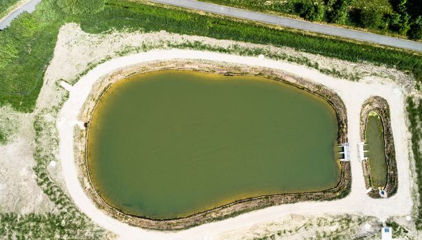 Aerial view of a rain retention basin at the edge of a new development, taken vertically, Germany