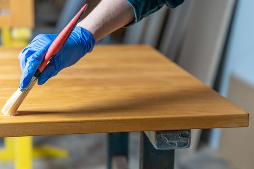 applying varnish to the wooden surface by means of a brush in the joinery.