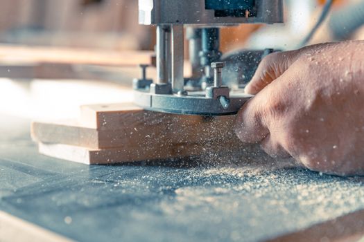 Milling wood in the joinery using manual mechanical cutters. Flying sawdust in the air. Copy space