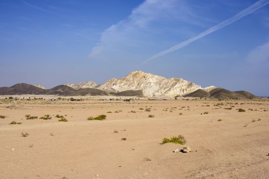 Panorama with a village in the desert and mountains in Ras Al Jinz, Oman