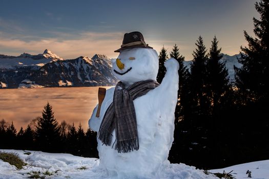 snow man in the swiss alps during sunset