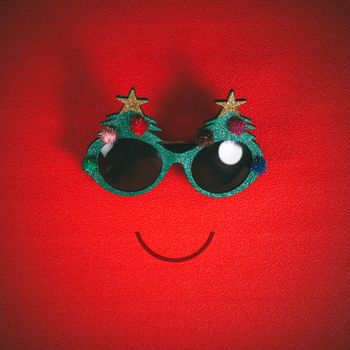 Christmas glasses that decoration with Christmas tree and red ball on red background