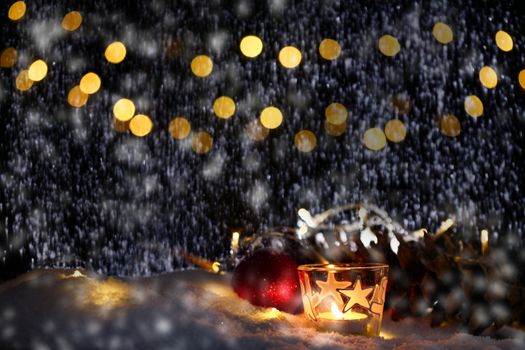 christmas theme with candles, snow, pine cone and christmas light with pokeh effect