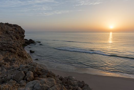 Sunrise over cliffs and sea of Oman (Gulf of Oman) wild coast of Ras Al Jinz, Sultanate of Oman