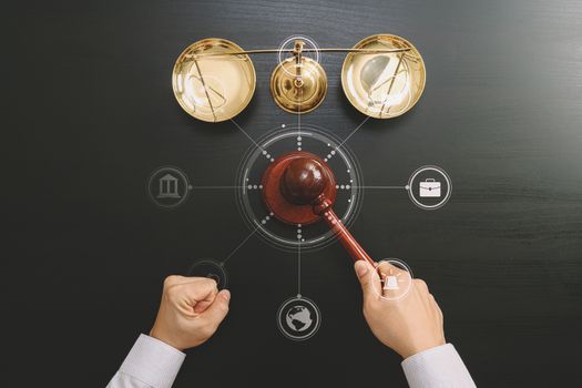 justice and law concept.Top view of Male judge hand in a courtroom with the gavel and brass scale on dark wood table with Vr diagram