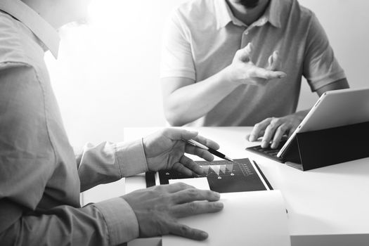 Businessmen working together on a document and using smart phone and digital tablet and laptop computer in modern office,black and white                                                     