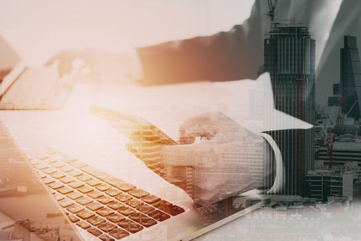 Hands of businessman using mobile phone in modern office with laptop and digital tablet computer ,with city exposure