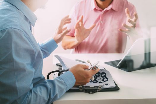 Medical doctor using mobile phone and consulting businessman patient having exam as Hospital professionalism concept 