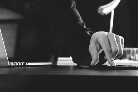 businessman using digital tablet and laptop computer and document in modern office,black and white