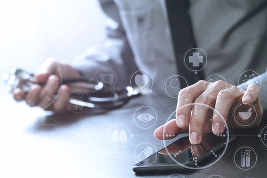 close up of smart medical doctor working with mobile phone and stethoscope on dark wooden desk with virtual reality icon diagram 