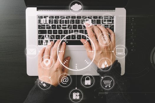 top view of businessman typing keyboard with laptop computer on wooden desk in modern office with virtual reality icon diagram   