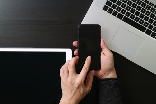 cyber security internet and networking concept.Businessman hand working with mobile phone on laptop computer background