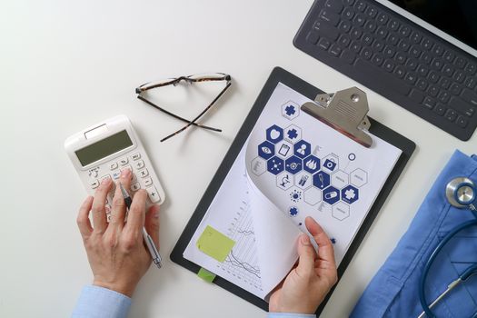 top view of Healthcare costs and fees concept.Hand of smart doctor used a calculator for medical costs in modern hospital 