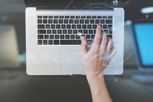 top view of businessman typing keyboard with laptop computer on wooden desk in modern office with virtual reality icon diagram   