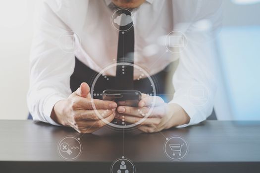 close up of businessman working with smart phone on wooden desk in modern office with virtual icon diagram