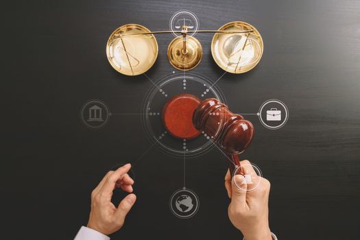 justice and law concept.Top view of Male judge hand in a courtroom with the gavel and brass scale on dark wood table with Vr diagram