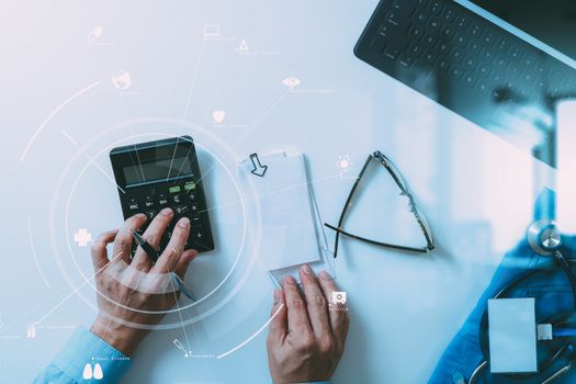 top view of Healthcare costs and fees concept.Hand of smart doctor used a calculator for medical costs in modern hospital with VR icon diagram