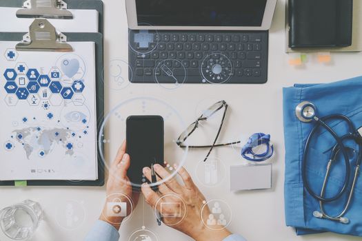 top view of smart medical doctor working with mobile phone and laptop computer and stethoscope on dark wooden desk with virtual reality icon diagram 