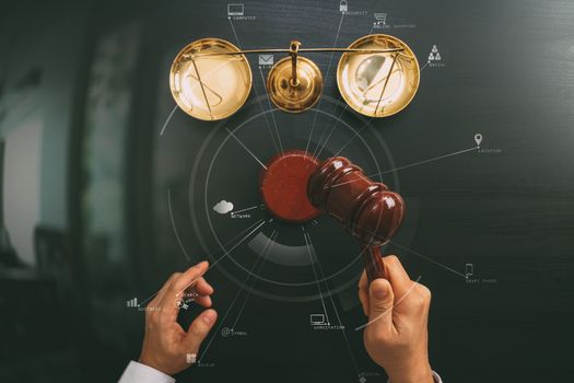 justice and law concept.Top view of Male judge hand in a courtroom with the gavel and brass scale on dark wood table with Vr diagram