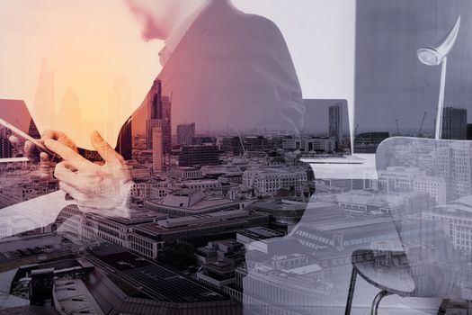 businessman working with smart phone and digital tablet and laptop computer in modern office with London city exposure  