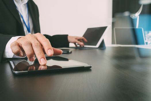 businessman working with smart phone and digital tablet and laptop computer in modern office with glass reflected view  