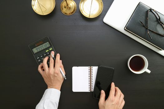 justice and law concept.businessman or lawyer or accountant working on accounts using a calculator and laptop computer and documents in modern office