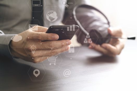 businessman using VOIP headset with mobile phone and concept communication call center on wooden desk with virtual reality icon diagram