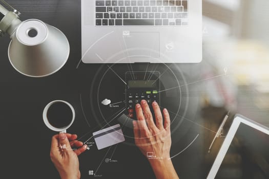 Internet shopping concept.Top view of hands working with calculator and laptop and credit card and tablet computer on dark wooden table background with Vr diagram