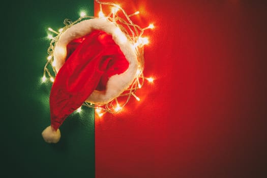 Greeting Season concept.Santa Claus hat with christmas light on red and green background