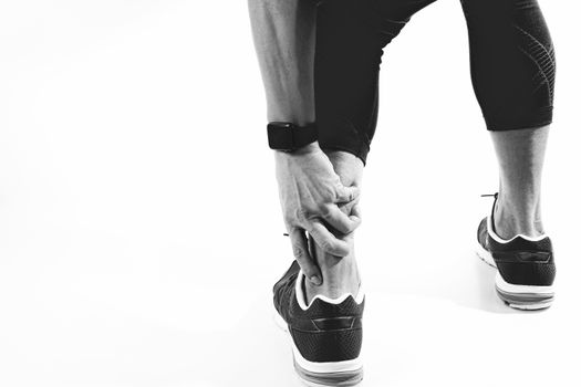 Runner sportsman holding ankle in pain with Broken twisted joint running sport injury and Athletic man touching foot due to sprain,black and white