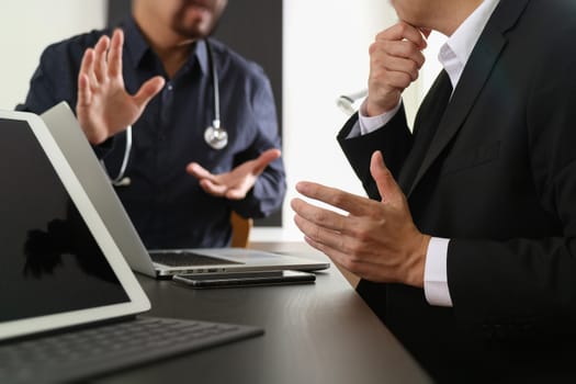 Medical co working concept,Doctor working with smart phone and digital tablet and laptop computer to meeting his team in modern office at hospital