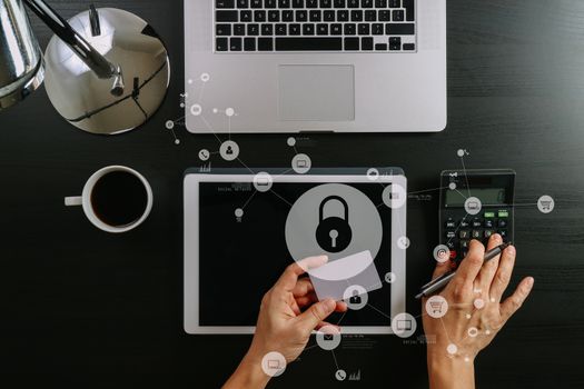 cyber security concept.Top view of hands working with calculator and laptop and credit card and tablet computer on dark wooden table background