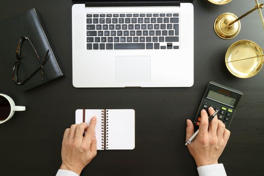 justice and law concept.businessman or lawyer or accountant working on accounts using a calculator and laptop computer and documents in modern office