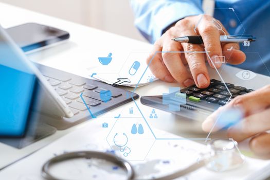 Healthcare costs and fees concept.Hand of smart doctor used a calculator for medical costs in modern hospital with VR icon diagram