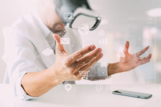 businessman wearing virtual reality goggles in modern office with mobile phone using with VR headset with screen icon diagram