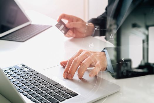 businessman making credit card purchase online with laptop computer on modern desk with VR icon diagram