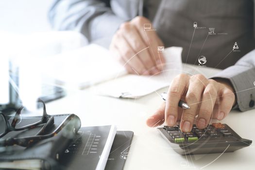 businessman hand working with finances about cost and calculator and latop with mobile phone on withe desk in modern office with VR icon diagram