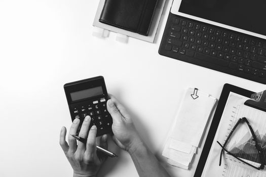 top view of businessman hand working with finances about cost and calculator and latop with mobile phone on withe desk in modern office,black with white