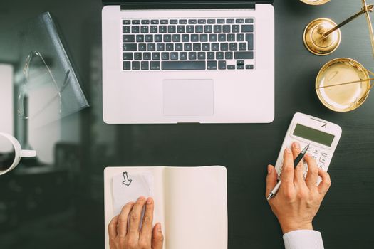 justice and law concept.businessman or lawyer or accountant working on accounts using a calculator and laptop computer and documents in modern office