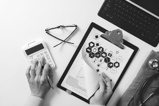 top view of Healthcare costs and fees concept.Hand of smart doctor used a calculator for medical costs in modern hospital,black with white