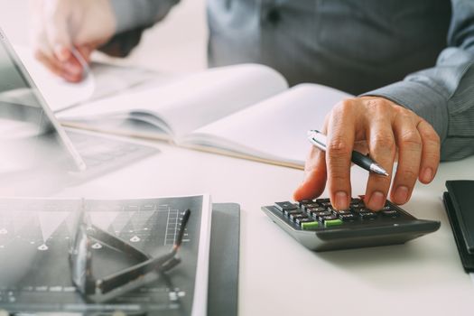 businessman hand working with finances about cost and calculator and latop with mobile phone on withe desk in modern office 