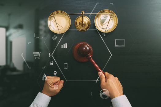 justice and law concept.Top view of Male judge hand in a courtroom with the gavel and brass scale on dark wood table with Vr diagram