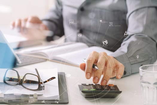 businessman hand working with finances about cost and calculator and latop with mobile phone on withe desk in modern office with VR icon diagram