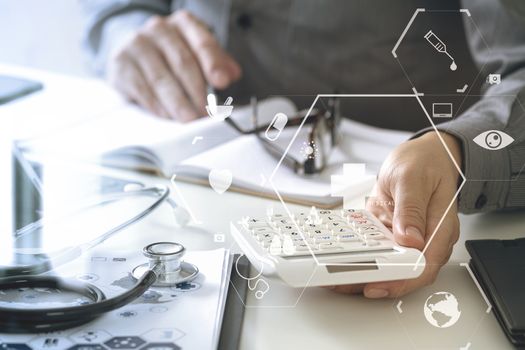 Healthcare costs and fees concept.Hand of smart doctor used a calculator for medical costs in modern hospital with VR icon diagram