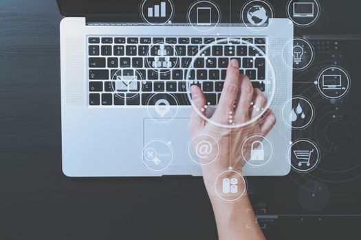 top view of businessman typing keyboard with laptop computer on wooden desk in modern office with virtual reality icon diagram   