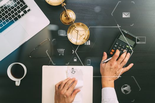 justice and law concept.businessman or lawyer or accountant working on accounts using a calculator and laptop computer and documents with Vr diagram