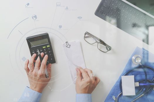 top view of Healthcare costs and fees concept.Hand of smart doctor used a calculator for medical costs in modern hospital with VR icon diagram