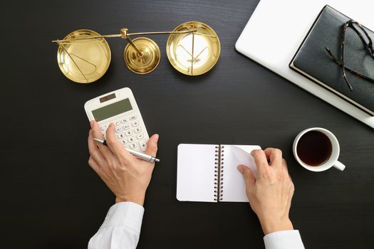 justice and law concept.businessman or lawyer or accountant working on accounts using a calculator and laptop computer and documents in modern office