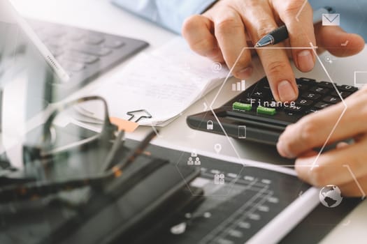 close up of businessman hand working with finances about cost and calculator and latop with mobile phone on withe desk in modern office with VR icon diagram